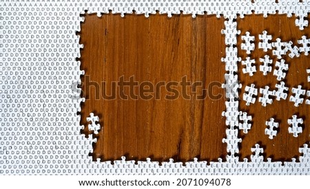 Incomplete jigsaw puzzle on wooden table