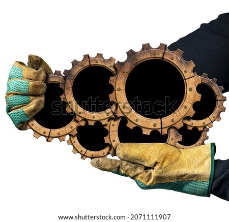 Gloved hands holding a group of seven wooden cogwheels (gears) with copy space, isolated on white background. Lumber industry concept.
