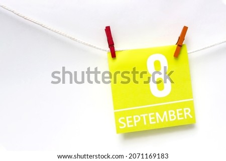September 8th. Day 8 of month, Calendar date. Paper cards with calendar day hanging rope with clothespins on white background. Autumn month, day of the year concept