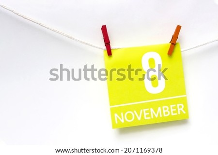 November 8th. Day 8 of month, Calendar date. Paper cards with calendar day hanging rope with clothespins on white background. Autumn month, day of the year concept
