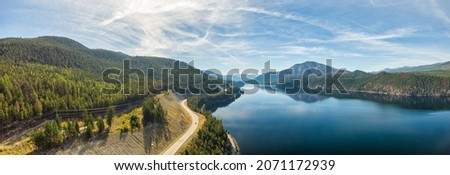 Aerial panoramic view of a scenic highway around mountains. East Kootenay, British Columbia, Canada. Royalty-Free Stock Photo #2071172939