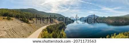 Aerial panoramic view of a scenic highway around mountains. East Kootenay, BC, Canada. Royalty-Free Stock Photo #2071173563