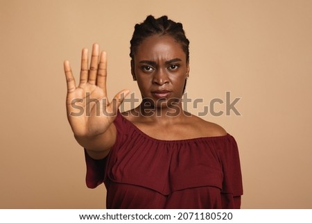 Young angry african american woman in casual outfit making the hand stop sign against beige studio background, closeup, copy space. Stop abuse, discrimination, violence concept Royalty-Free Stock Photo #2071180520