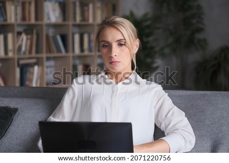 Focused businesswoman work laptop pc at home office. Stylish woman chatting surfing internet on computer sitting couch. Pensive blonde lady browsing searching information online digital technology