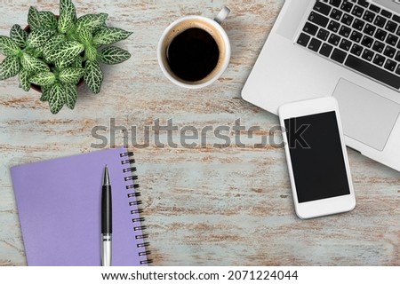 Modern office desk with laptop, coffee cup and pen on wood table.
