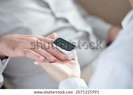 Close-up image of doctor measuring oxygen saturation of patient with pulse oximeter device Royalty-Free Stock Photo #2071225991