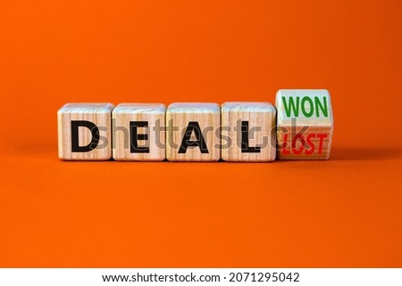 Deal lost or won symbol. Turned a wooden cube and changed words deal lost to deal won. Beautiful orange table, orange background, copy space. Business and deal lost or won concept.