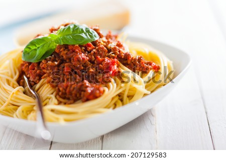 Dish of Italian spaghetti with rich tomato based Bolognaise sauce garnished with fresh basil leaves for a healthy Mediterranean diet