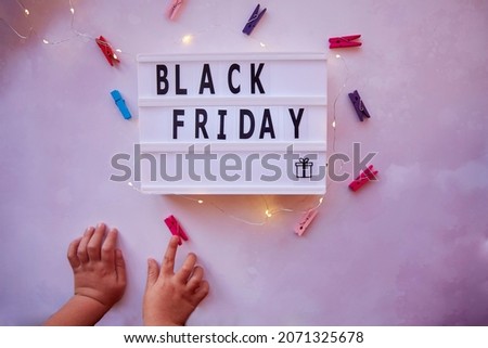 Signboard with text Black Friday and present. Baby curiosity for shopping with clothespins. Top view. High quality photo