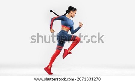 Runner running isolated on white background. A strong athletic, women sprinter wearing in the sportswear, fitness and sport motivation. Run concept with copy space. Dynamic movement Royalty-Free Stock Photo #2071331270