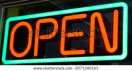Green and red neon open sign at night. Store, bar, business concepts