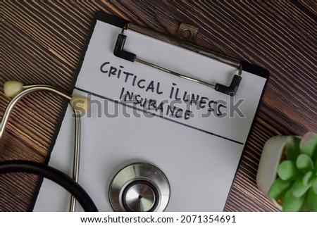 Critical Illness Insurance write on a paperwork isolated on Wooden Table.