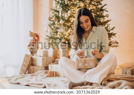 Woman opening her present on Christmas Royalty-Free Stock Photo #2071362029