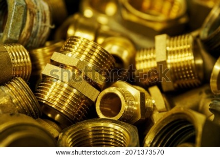 Brass fittings and couplings side by side on a pile. Royalty-Free Stock Photo #2071373570