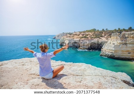 Girl looking out on the ocean. Lagos, Algarve Coast, Portugal Royalty-Free Stock Photo #2071377548