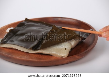 A uncooked flatfish with seaweed