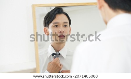 Asian man looking in the mirror Royalty-Free Stock Photo #2071405088