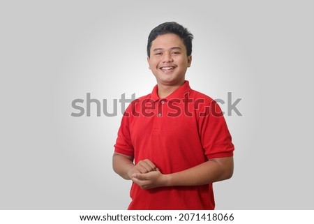 Portrait of attractive Asian man in red polo shirt posing professional gesture. Isolated image on white background