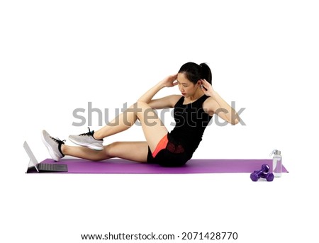 Asian pretty sporty woman in black sportwear stretching on the purple yoga mat on the white background with dumbbell and water bottle.