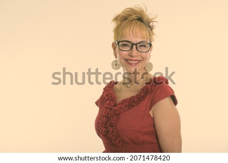 Studio shot of beautiful senior Asian businesswoman with short hair against white background