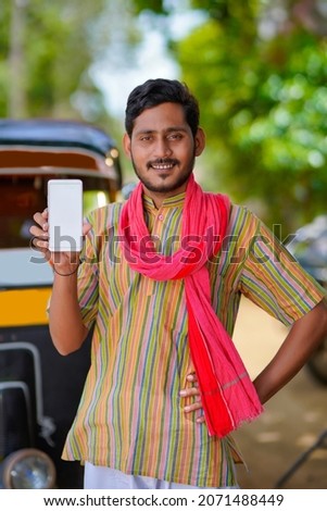 Indian auto rickshaw three-wheeler taxi driver man showing smartphone.