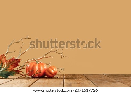 Happy Thanksgiving Day lush background. Orange Halloween pumpkins with golden branches on brown. party decoration with golden maple fall leaves. copy space