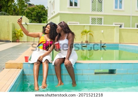 two black girls taking a selfie in a pool