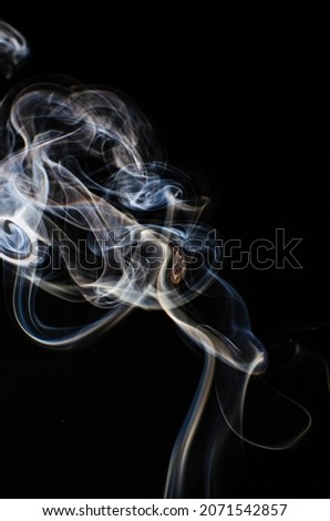 A vertical shot of smoke on a dark background