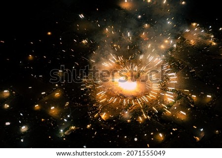 A diwali chakra spinning and emitting bright sparks which look like a picture of a galaxy.