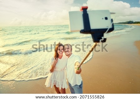 Dating and technology. Pretty young loving couple taking selfie together on smartphone on sea beach.
