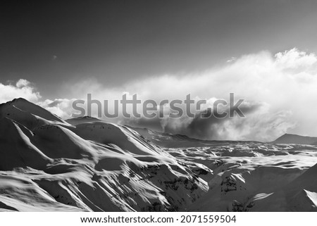 Black and white view on evening sunlight mountains in cloud. Snowy Caucasus Mountains at winter, Georgia, region Gudauri. Remote location. High contrast.