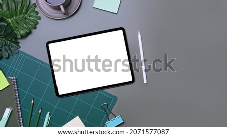 Above view designer workspace with digital tablet, coffee cup and stationery.