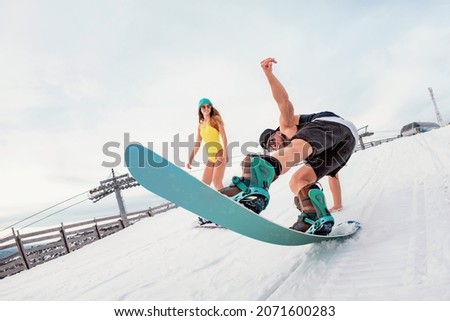 Young couple of snowboarders are having fun at ski resort. Winter holidays concept