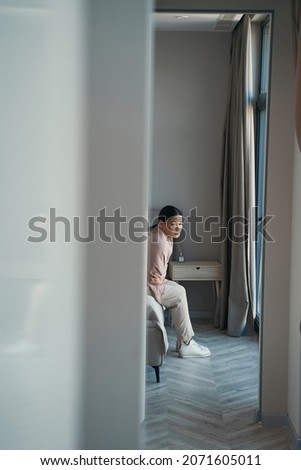 Sorrowful Asian woman spending day alone at home