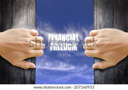"Financial Freedom" text in the sky behind 2 hands opening the wooden door. Royalty-Free Stock Photo #207160933