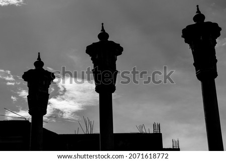 silhouette of three pillars of garden lights.