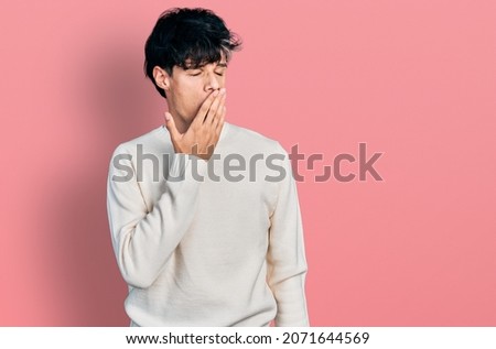 Handsome hipster young man wearing casual winter sweater bored yawning tired covering mouth with hand. restless and sleepiness. 