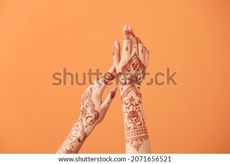 Beautiful female hands with henna tattoo on color background Royalty-Free Stock Photo #2071656521