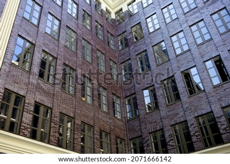 Tall building with large windows in the city center. Background from the windows outside view. A modern office building with a lot of staff. Free space for text on the background of the building