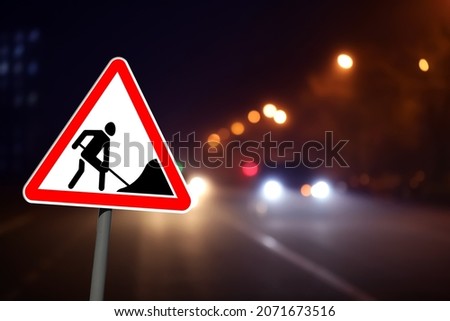 Traffic sign Road Works near highway in night. Bokeh effect