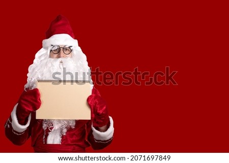 Christmas. The kind Santa Claus holds an empty cardboard frame. Place for advertising, for text, empty space