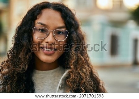 Young latin woman smiling happy standing at the city.