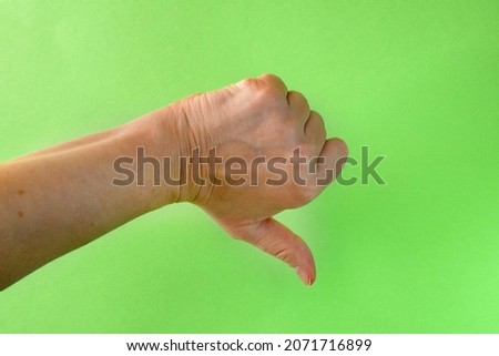 Thumbs down sign hand gesture on green screen. Simbol of approval dislike emotion. Closeup