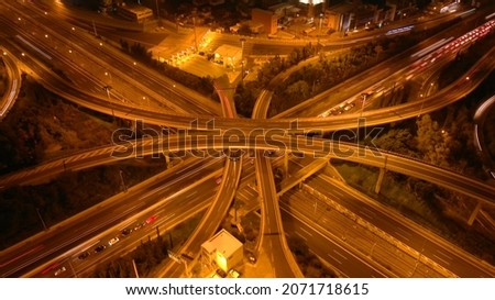 Aerial drone long exposure night shot of highway multilevel junction highway with light traffic leaving car headlights white and red trails