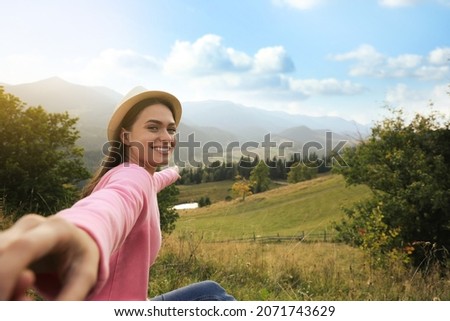 Young woman holding boyfriend's hand in mountains, space for text Royalty-Free Stock Photo #2071743629