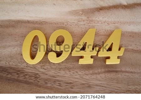 Golden Arabic numerals 0944 on a dark brown to white wood grain background.