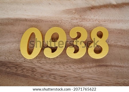 Golden Arabic numerals 0938 on a dark brown to white wood grain background.