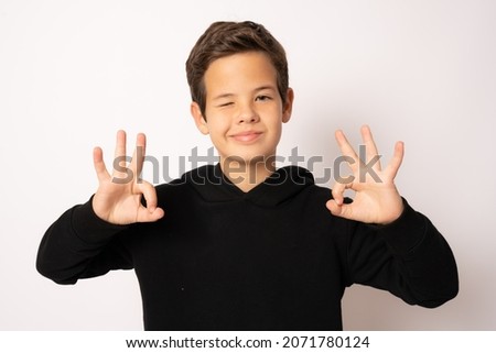 standing young cool boy doing okay sign isolated over white background