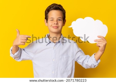 Great Idea. Little smiling boy holding speech bubble with copy space standing isolated over yellow background.