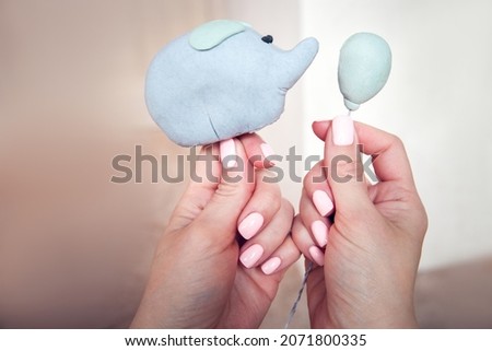 mastic elephant with balloon as a cake decoration in a women's hands